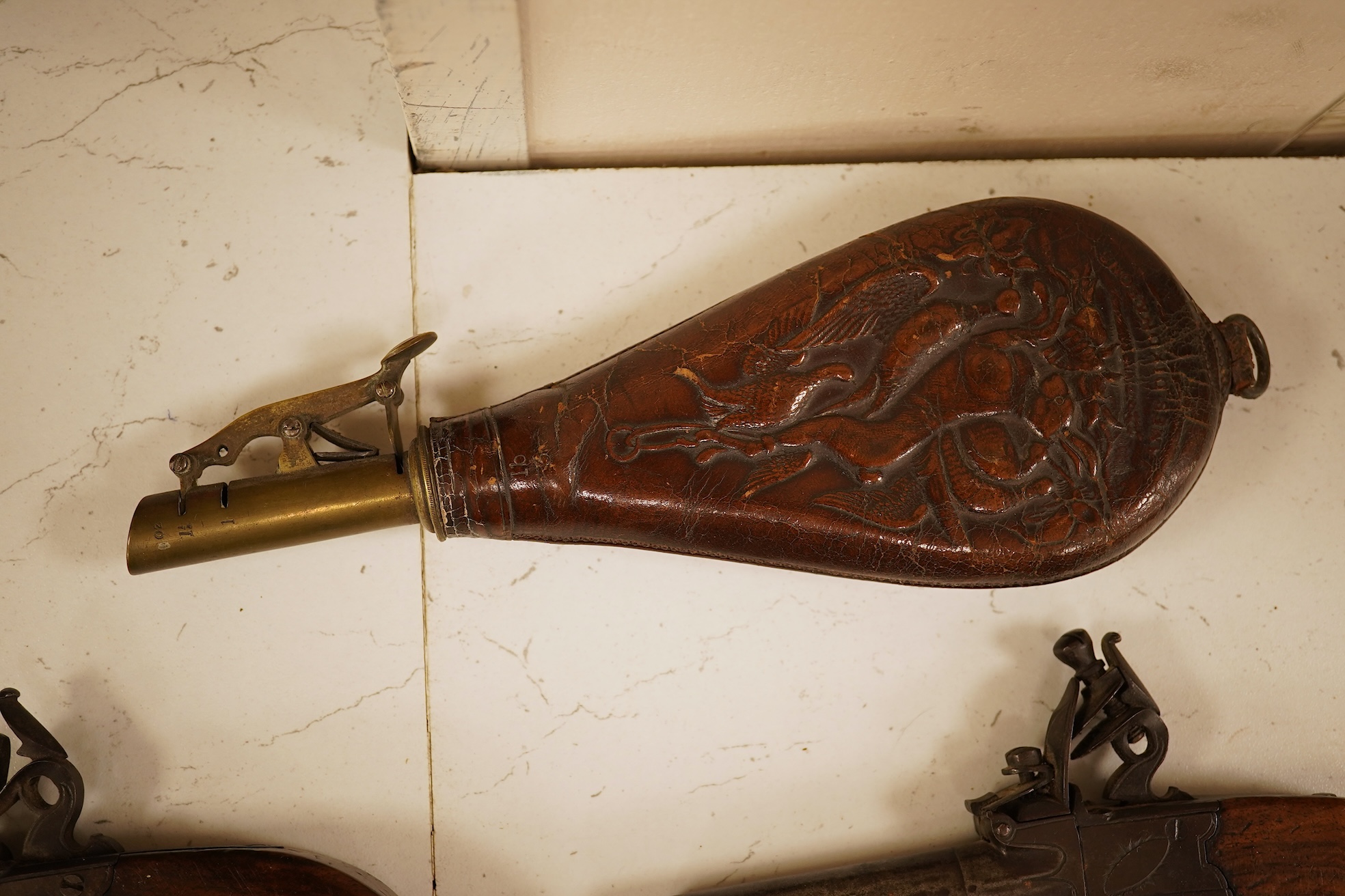 A pair of 19th century pocket pistols, shot flask and a brass musket, 81cm in length